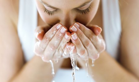 Woman washing her face with water