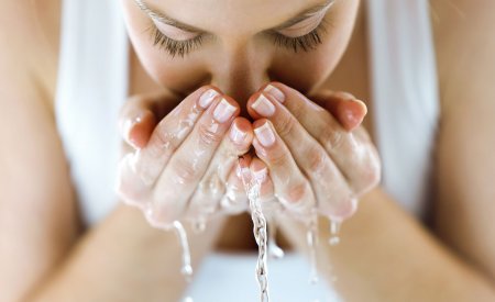 Woman washing her face with water